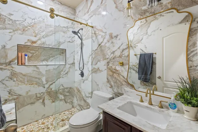 a bathroom with a sink a toilet and shower