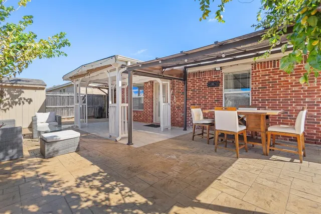 a view of a patio with a table and chairs and potted plants