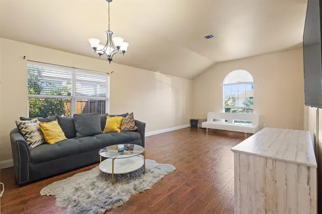 a living room with furniture and a chandelier