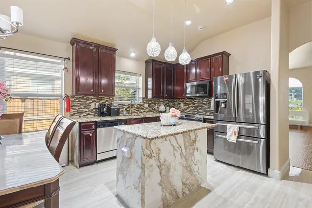a kitchen with stainless steel appliances granite countertop a sink refrigerator and cabinets