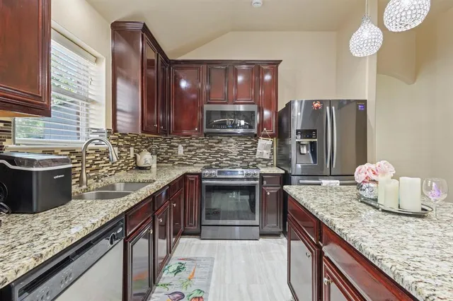 a kitchen with stainless steel appliances granite countertop a sink stove and refrigerator