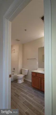 a kitchen with stainless steel appliances granite countertop a stove a sink and a refrigerator with wooden floor