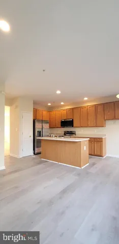 a kitchen with stainless steel appliances granite countertop a sink cabinets and wooden floor