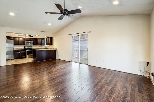 a view of a kitchen with a stove wooden floor and a ceiling fan