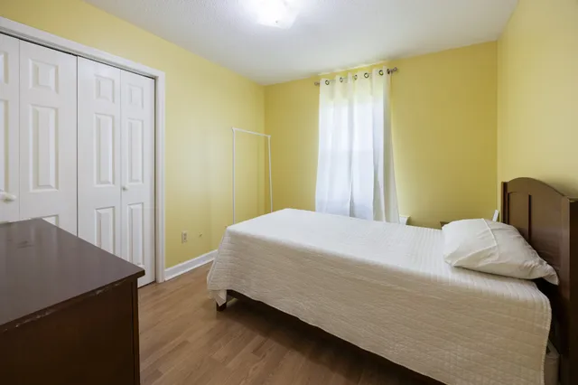 a bedroom with a bed and wooden floor