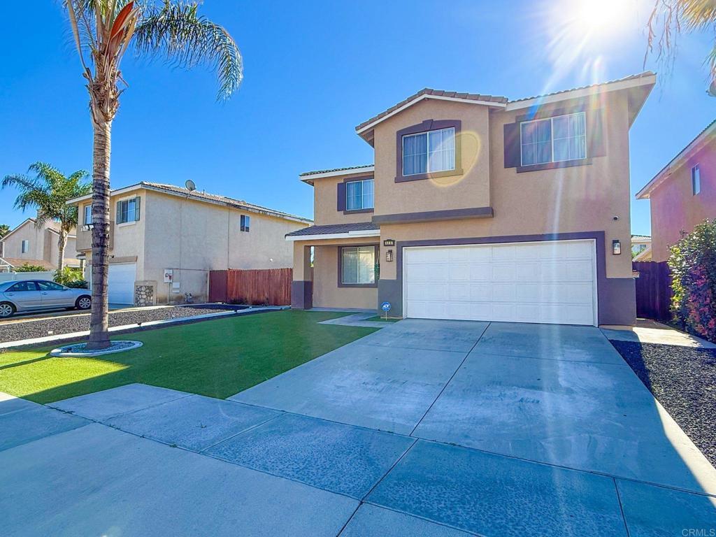a view of a house with a yard and a patio