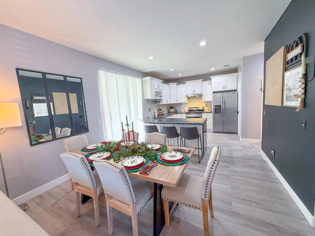 3237 Warley Road Hemet, CA 92545 - Photo 12 of 43 a view of a dining room with furniture a kitchen and wooden floor