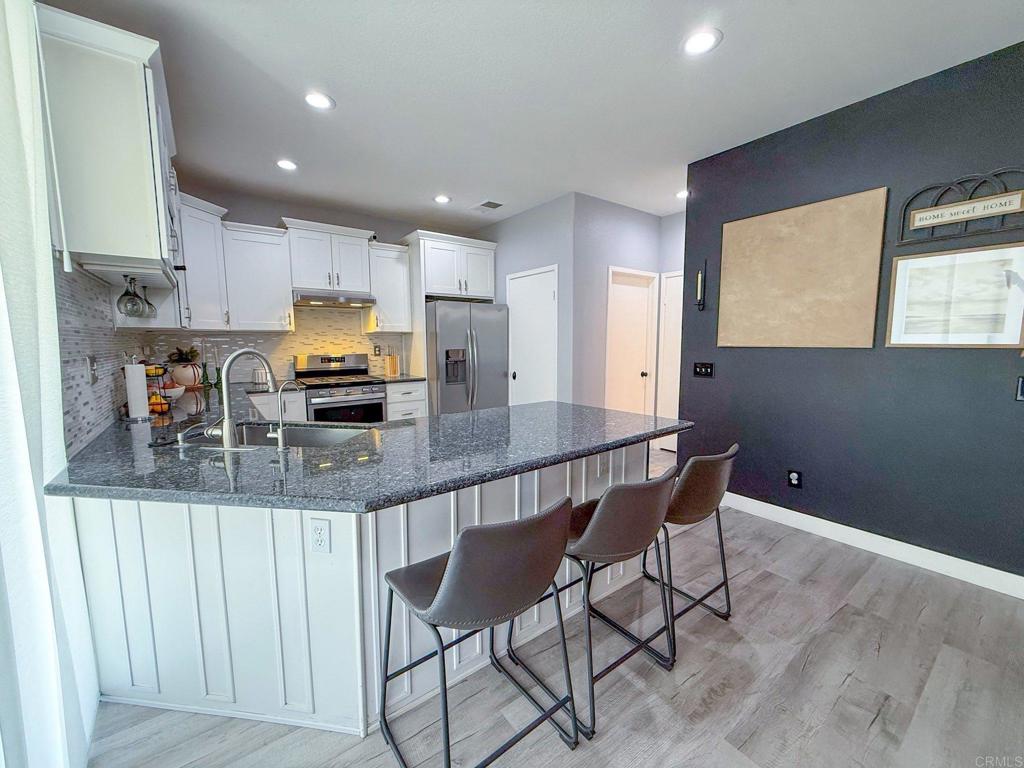 3237 Warley Road Hemet, CA 92545 - Photo 15 of 43 a kitchen with stainless steel appliances granite countertop a kitchen island a stove a cabinets a sink and a refrigerator