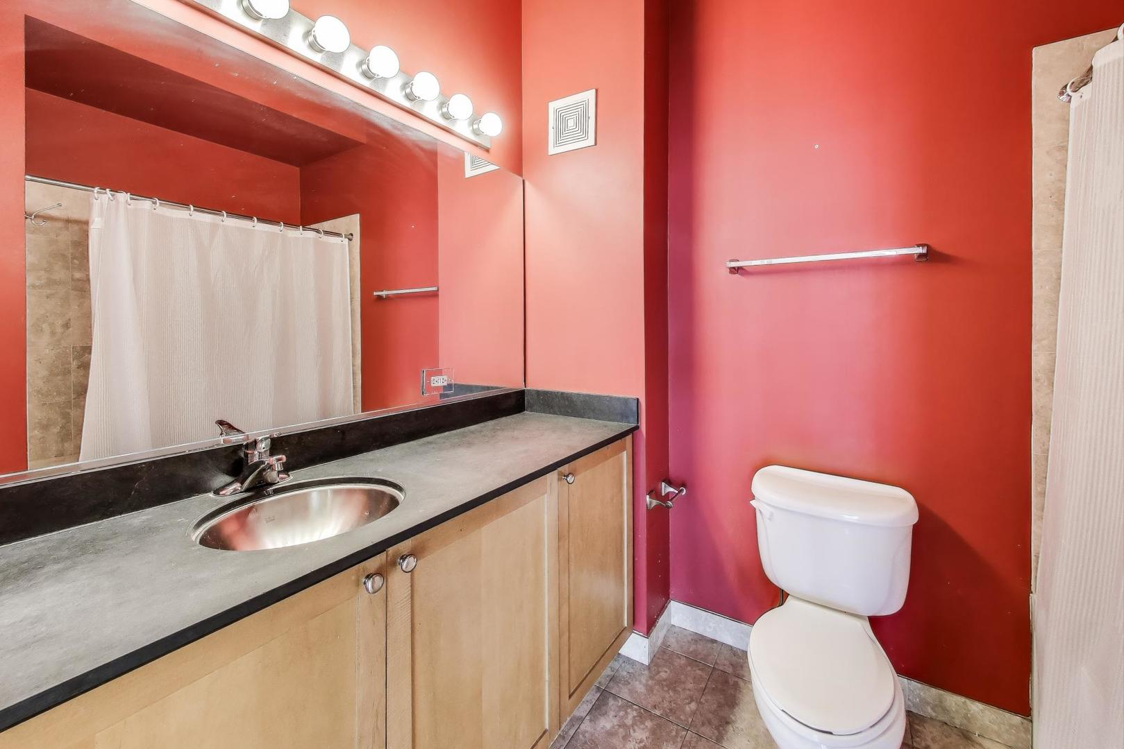 321 South Sangamon Street, Unit 605 Chicago, IL 60607 - Photo 26 of 36 a bathroom with a granite countertop toilet sink and mirror