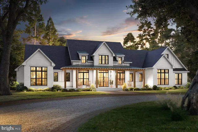 a front view of a house with a garden and trees