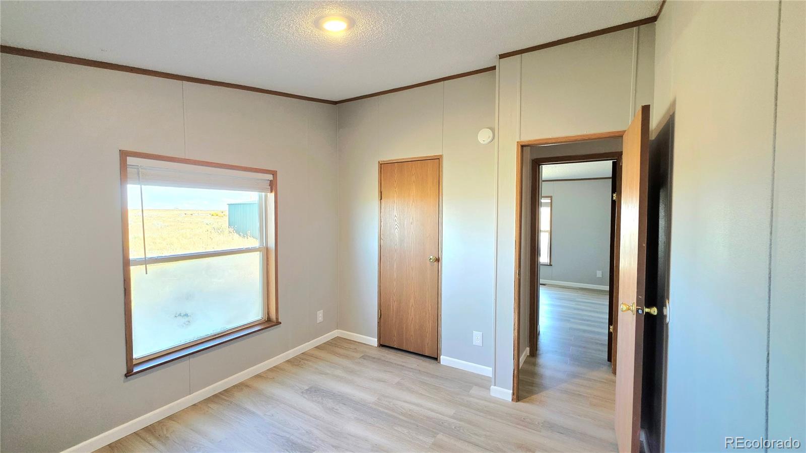 10754 County Road Olney Springs, CO 81062 - Photo 34 of 49 an empty room with wooden floor and a window