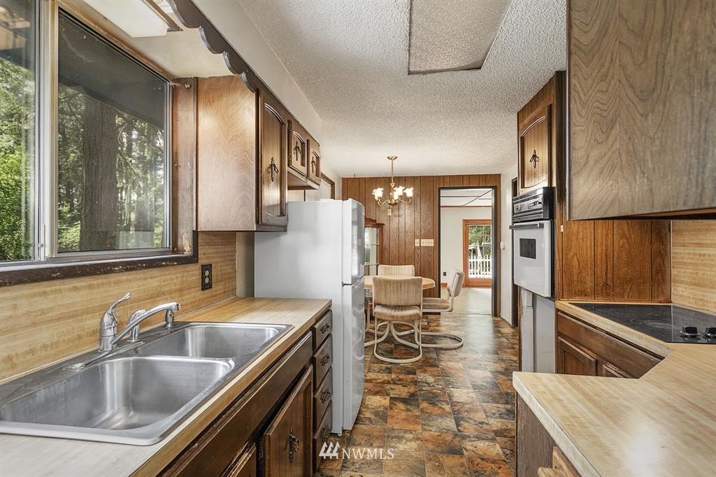 714 Ness' Corner Road Port Hadlock, WA 98339 - Photo 14 of 21 a kitchen with sink refrigerator and outdoor view