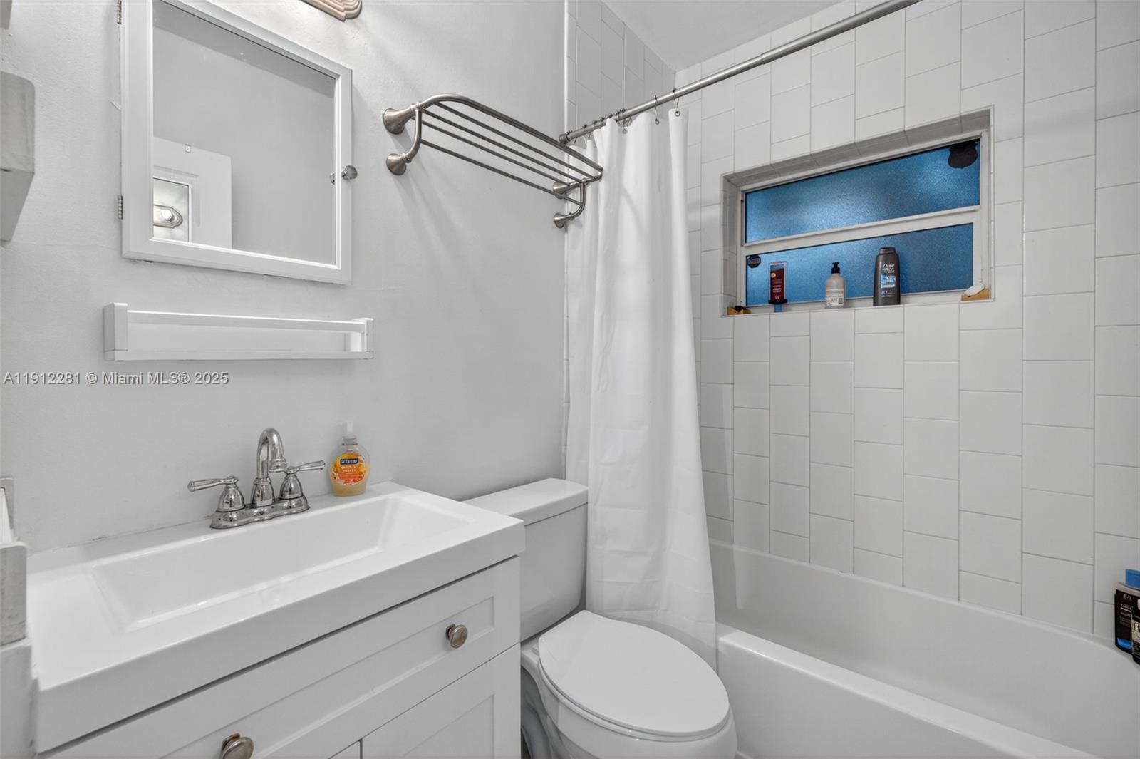 820 North Ocean Boulevard, Unit 1 Pompano Beach, FL 33062 - Photo 11 of 21 a bathroom with a sink a mirror a bathtub and shower