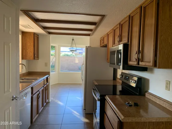 a kitchen with stainless steel appliances granite countertop a refrigerator a stove and a sink