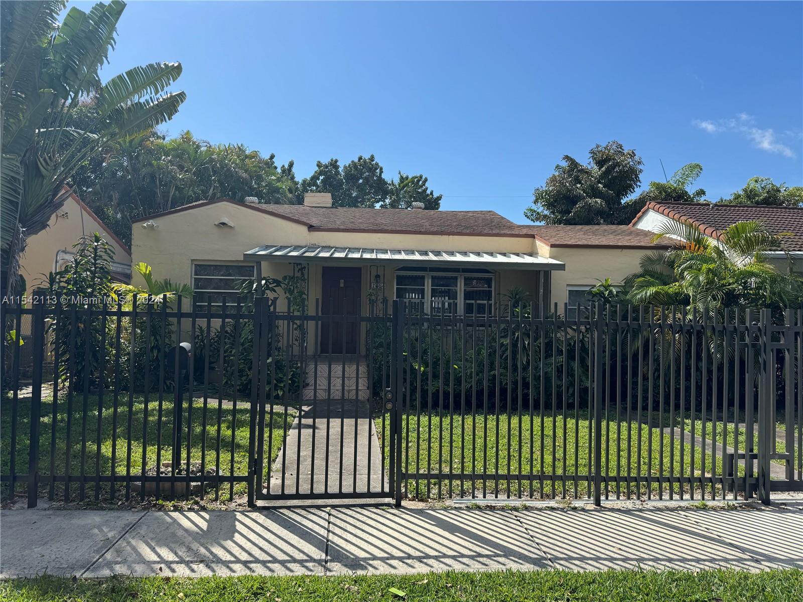 a view of a house with a small yard and wooden fence