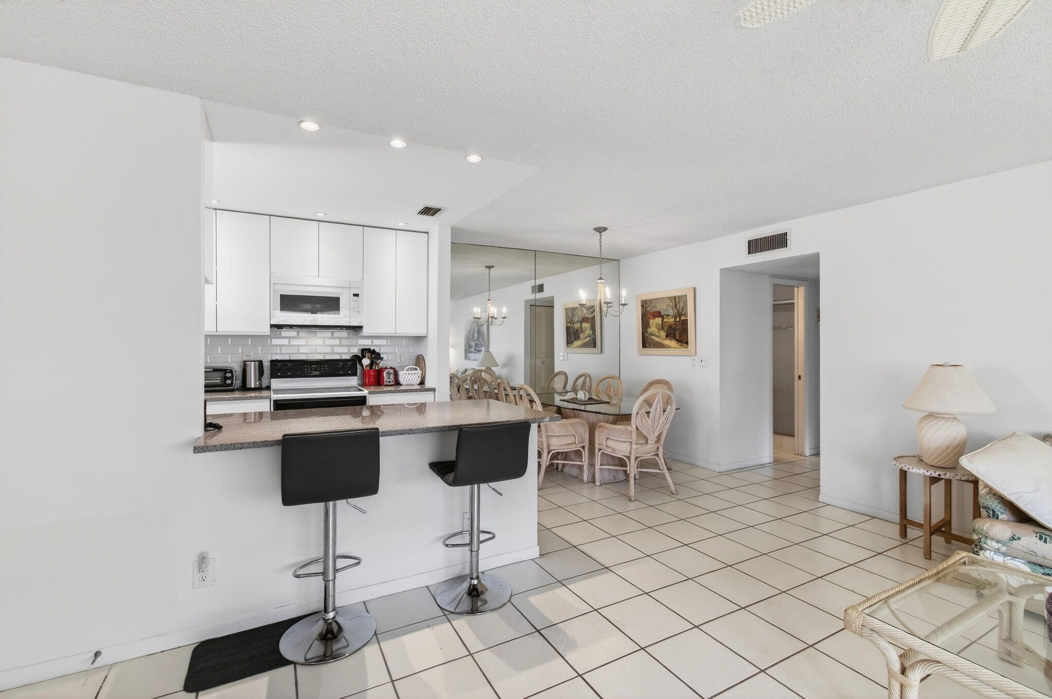 1327 High Point Way Southeast, Unit D Delray Beach, FL 33445 - Photo 17 of 53 a kitchen with stainless steel appliances kitchen island granite countertop a sink and cabinets