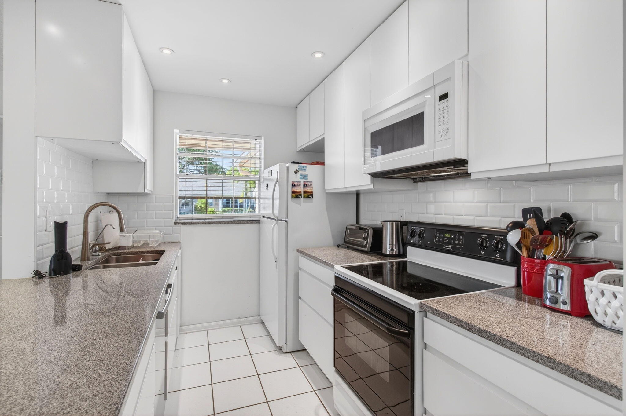 1327 High Point Way Southeast, Unit D Delray Beach, FL 33445 - Photo 19 of 53 a kitchen that has a sink and a stove