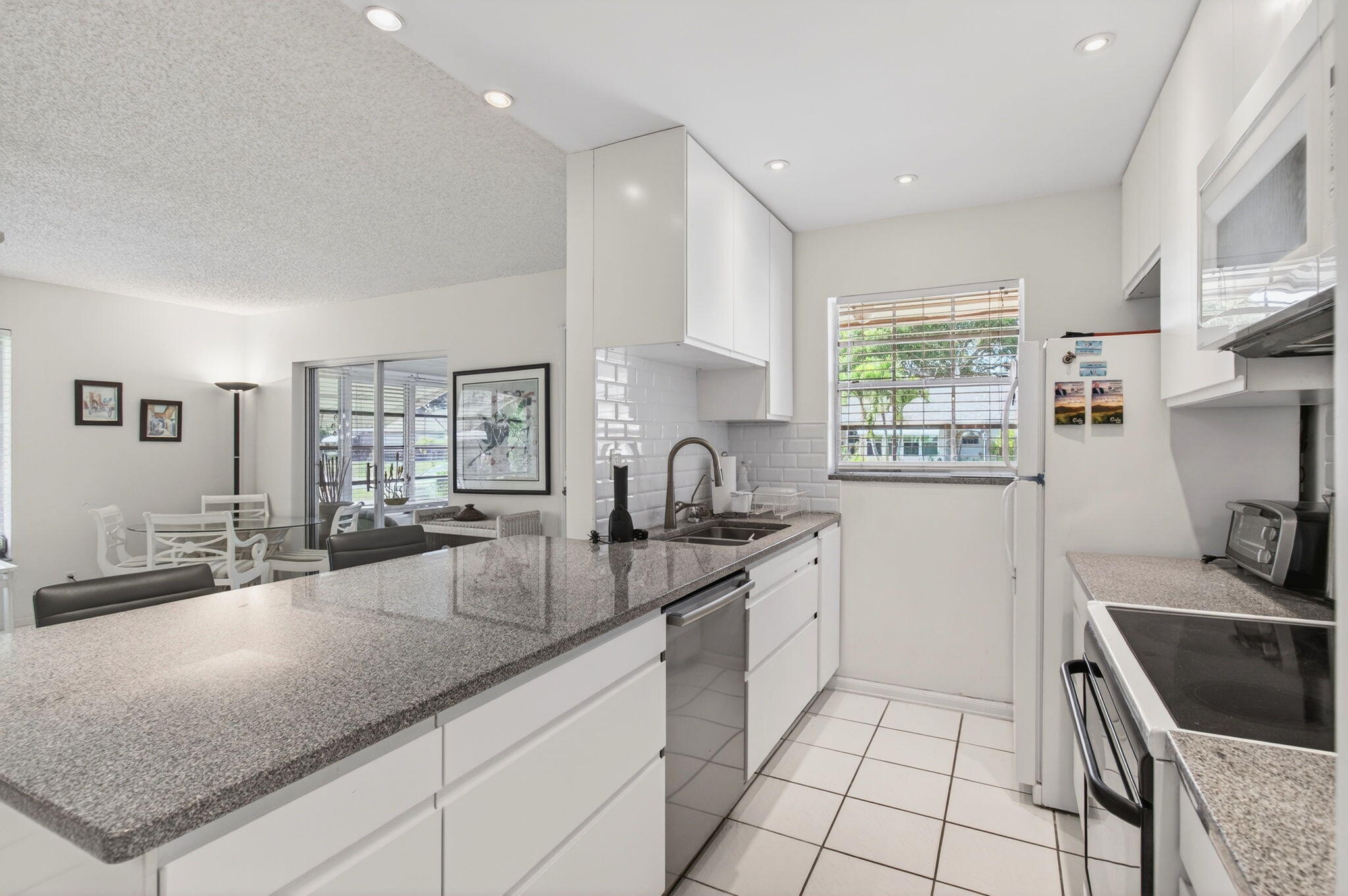 1327 High Point Way Southeast, Unit D Delray Beach, FL 33445 - Photo 20 of 53 a kitchen with stainless steel appliances granite countertop a sink stove and cabinets