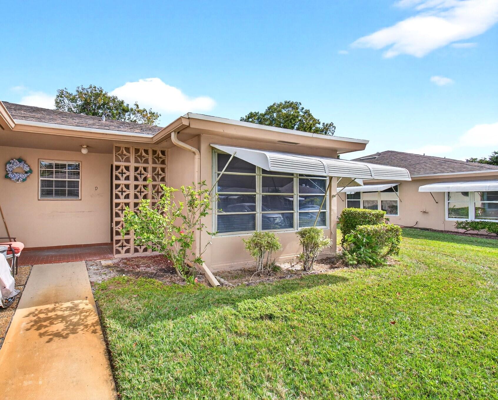 1327 High Point Way Southeast, Unit D Delray Beach, FL 33445 - Photo 2 of 53 a front view of a house with a yard
