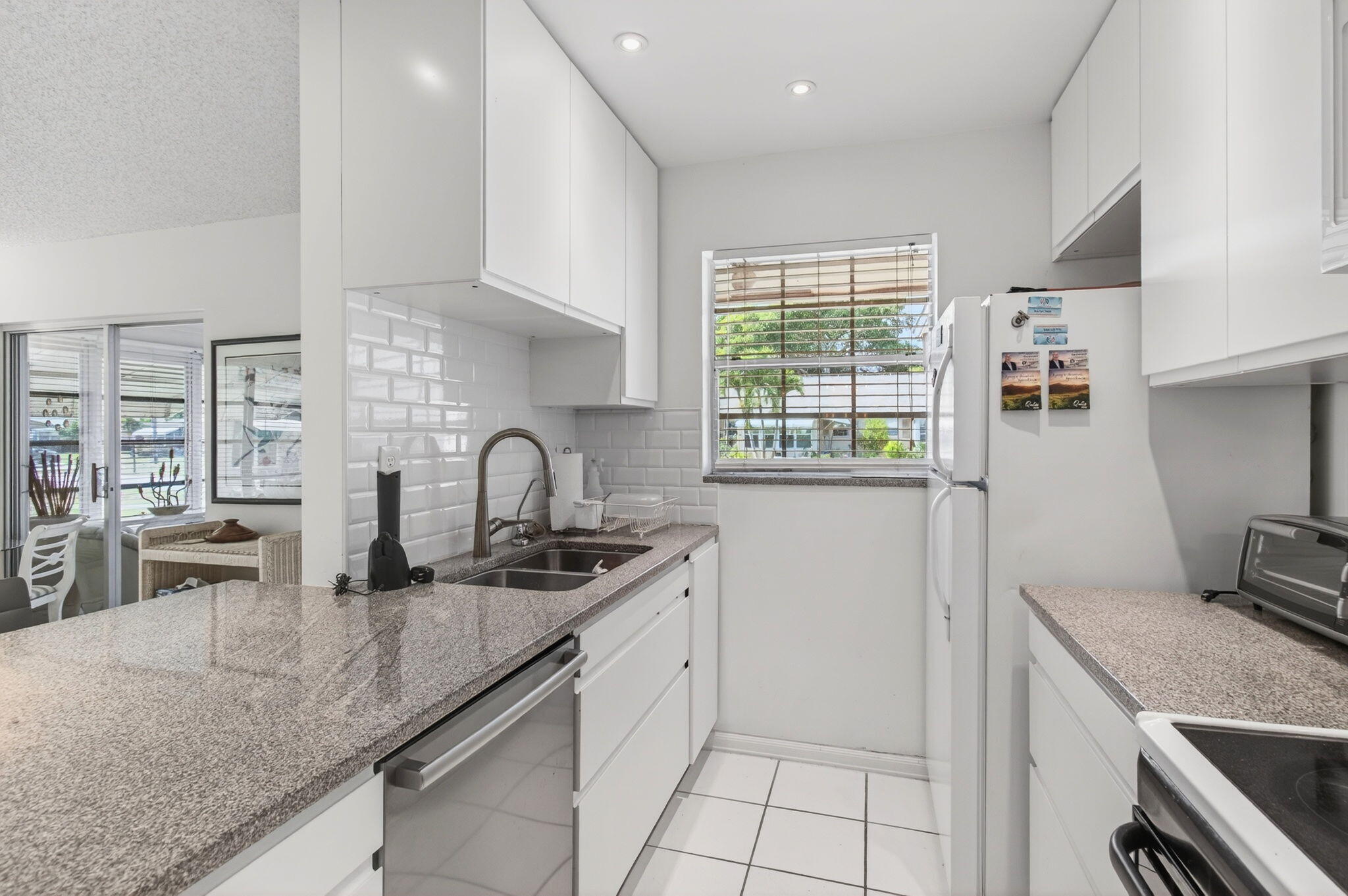 1327 High Point Way Southeast, Unit D Delray Beach, FL 33445 - Photo 21 of 53 a kitchen with stainless steel appliances granite countertop a sink stove and cabinets