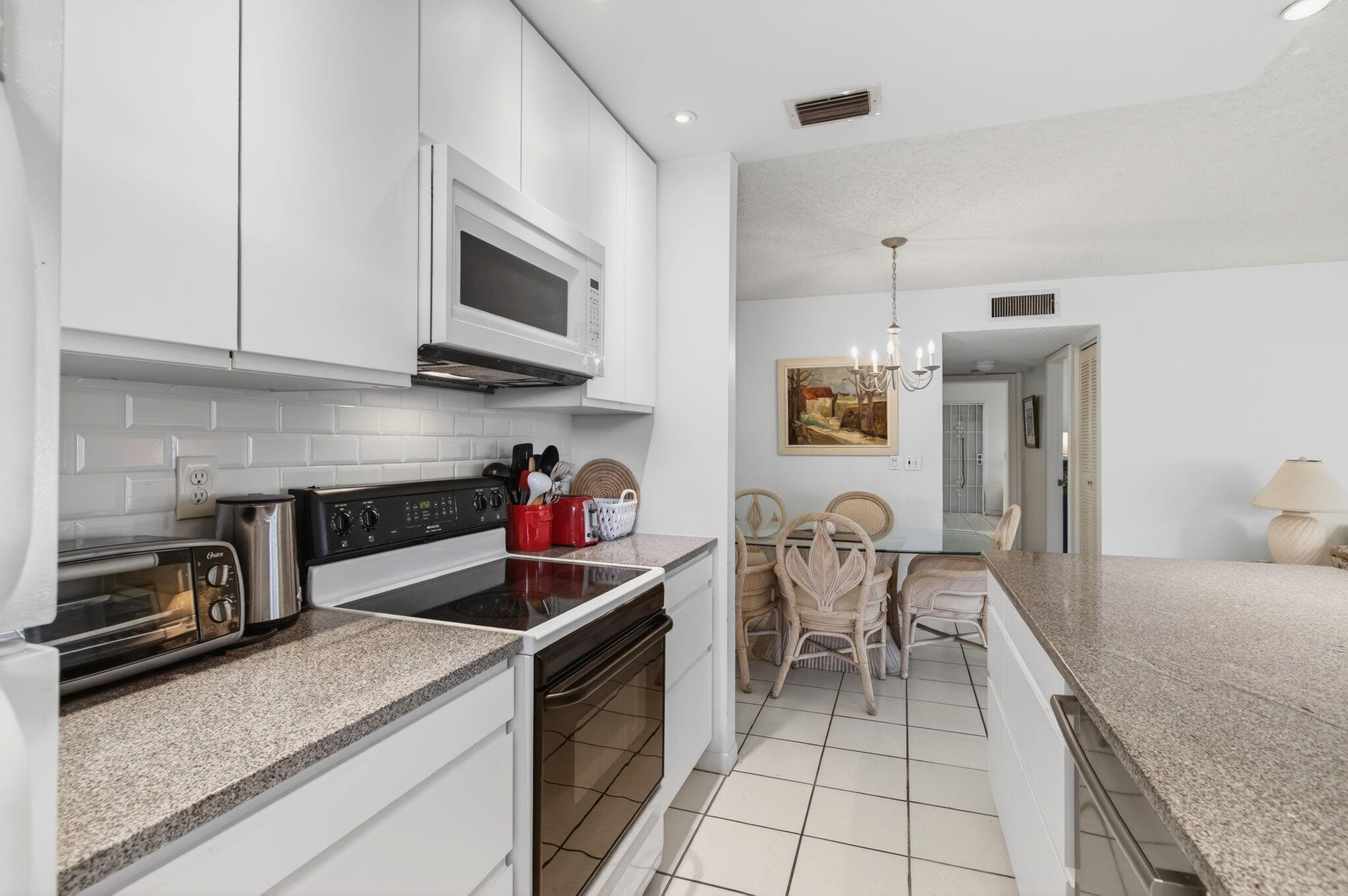 1327 High Point Way Southeast, Unit D Delray Beach, FL 33445 - Photo 22 of 53 a kitchen that has a microwave and a stove