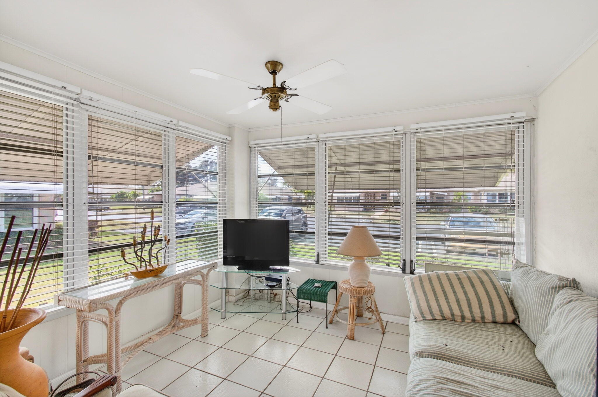1327 High Point Way Southeast, Unit D Delray Beach, FL 33445 - Photo 6 of 53 a living room with furniture a flat screen tv and a floor to ceiling window