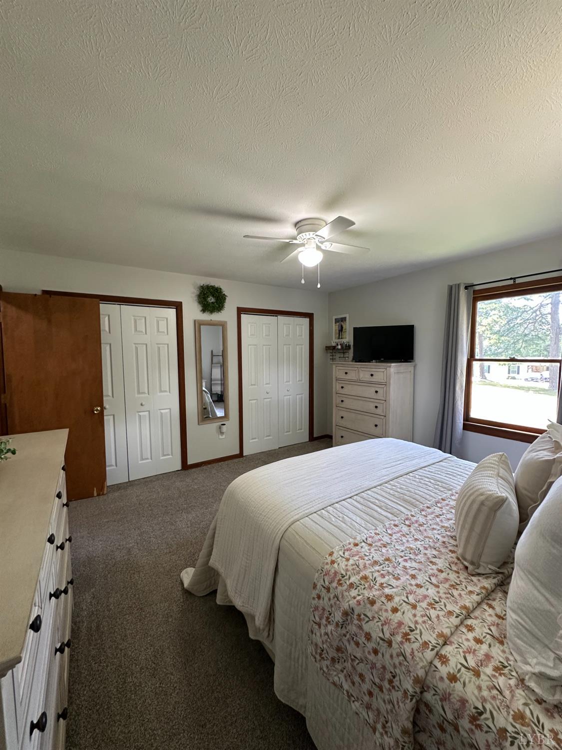 1524 Austin Road Gladstone, VA 24553 - Photo 13 of 30 a spacious bedroom with a large bed and a chandelier