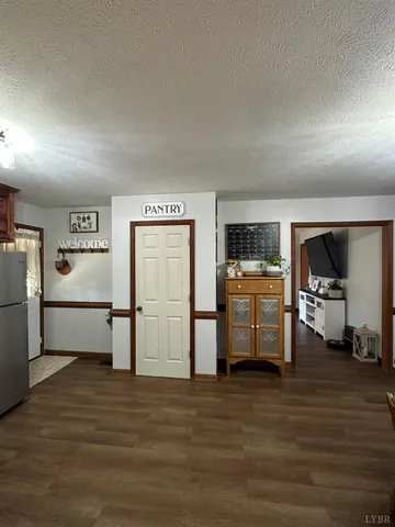 a room with furniture a flat screen tv and a refrigerator