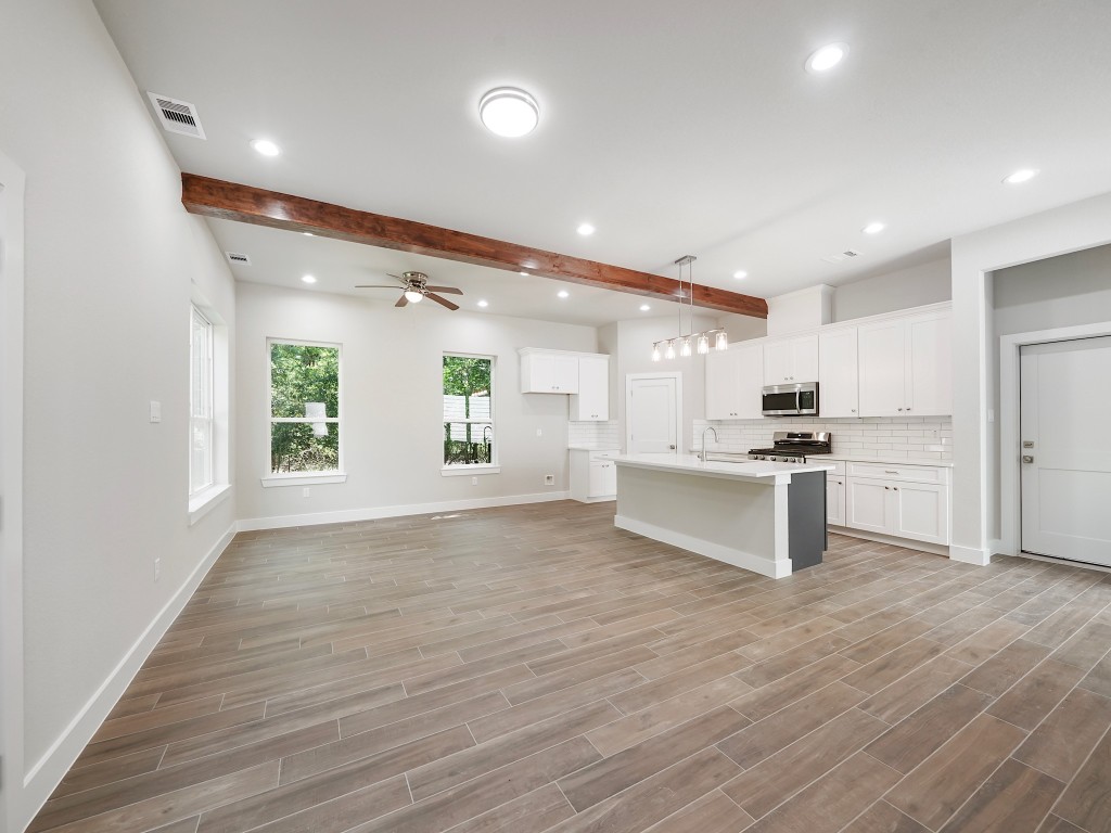 731 Magnolia Point Drive Houston, TX 77336 - Photo 11 of 35 a large kitchen with white cabinets and wooden floor