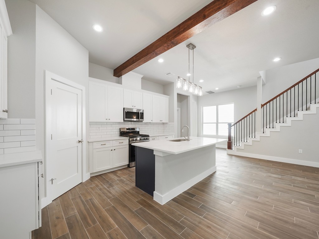 731 Magnolia Point Drive Houston, TX 77336 - Photo 13 of 35 a large white kitchen with kitchen island a stove a sink dishwasher and a refrigerator