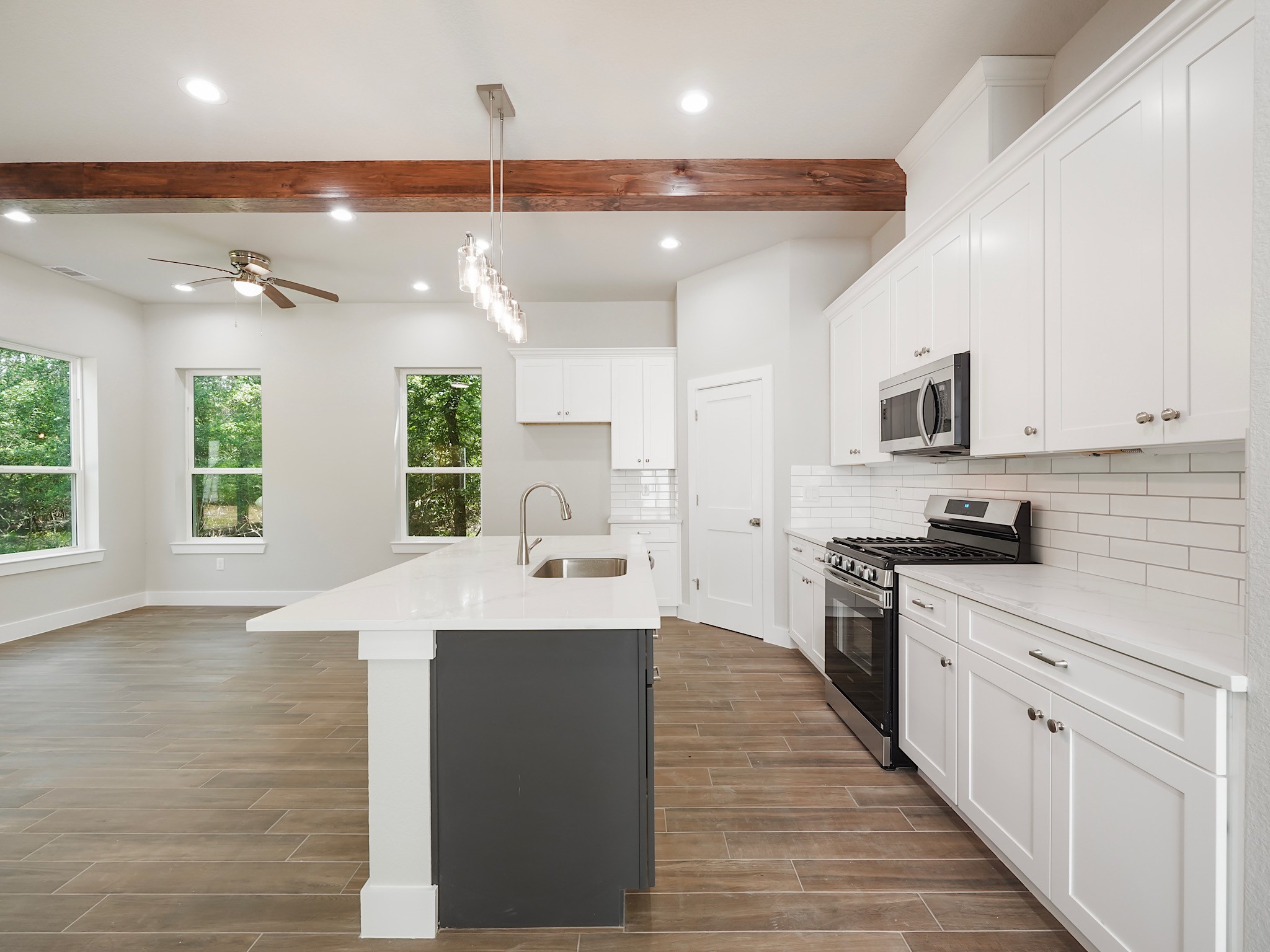 731 Magnolia Point Drive Houston, TX 77336 - Photo 8 of 36 a large kitchen with stainless steel appliances kitchen island granite countertop a stove a sink dishwasher and a microwave oven with white cabinets