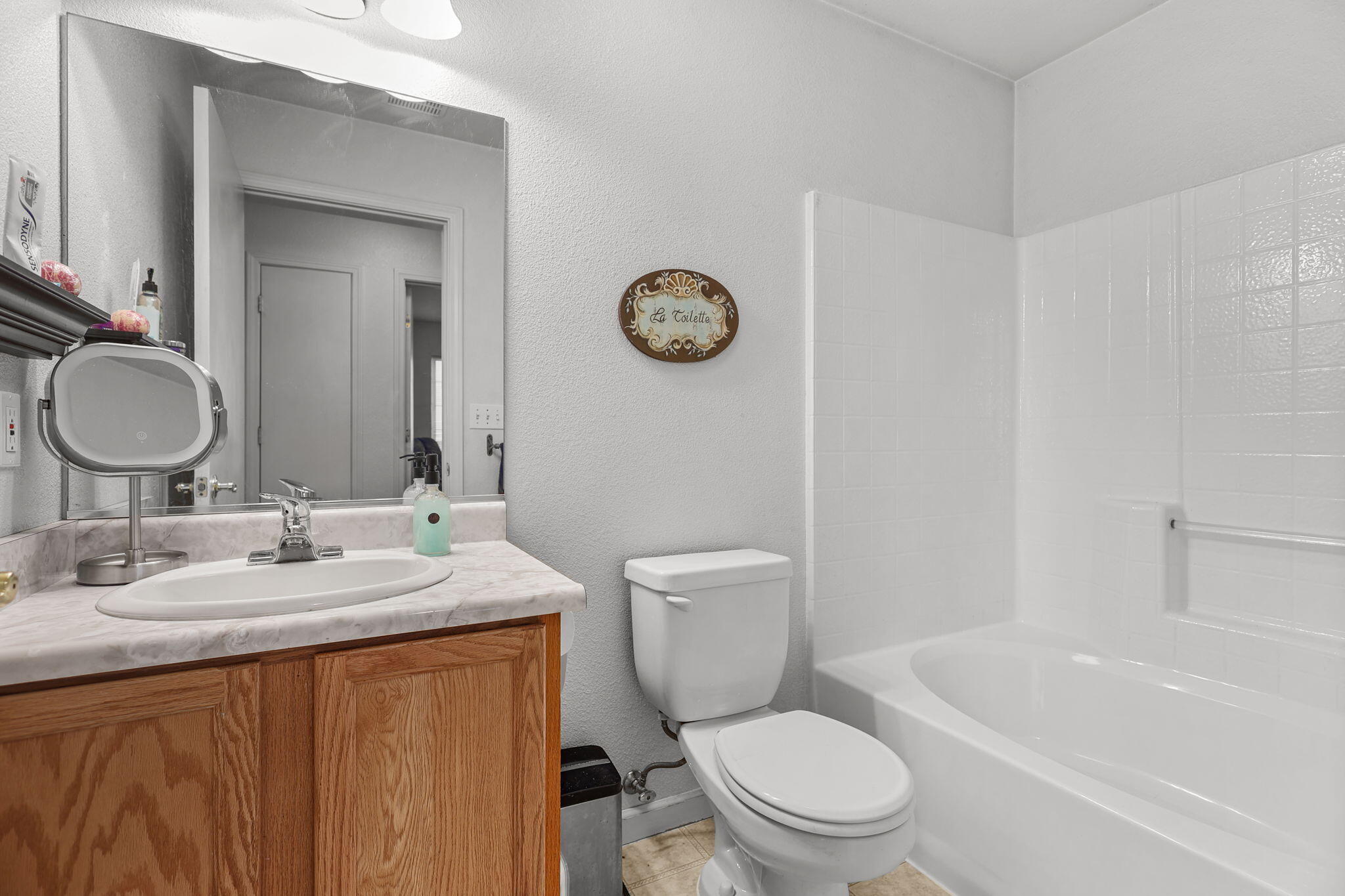 720 Stonebriar Trail Redding, CA 96003 - Photo 11 of 19 a bathroom with a granite countertop toilet a sink and a mirror