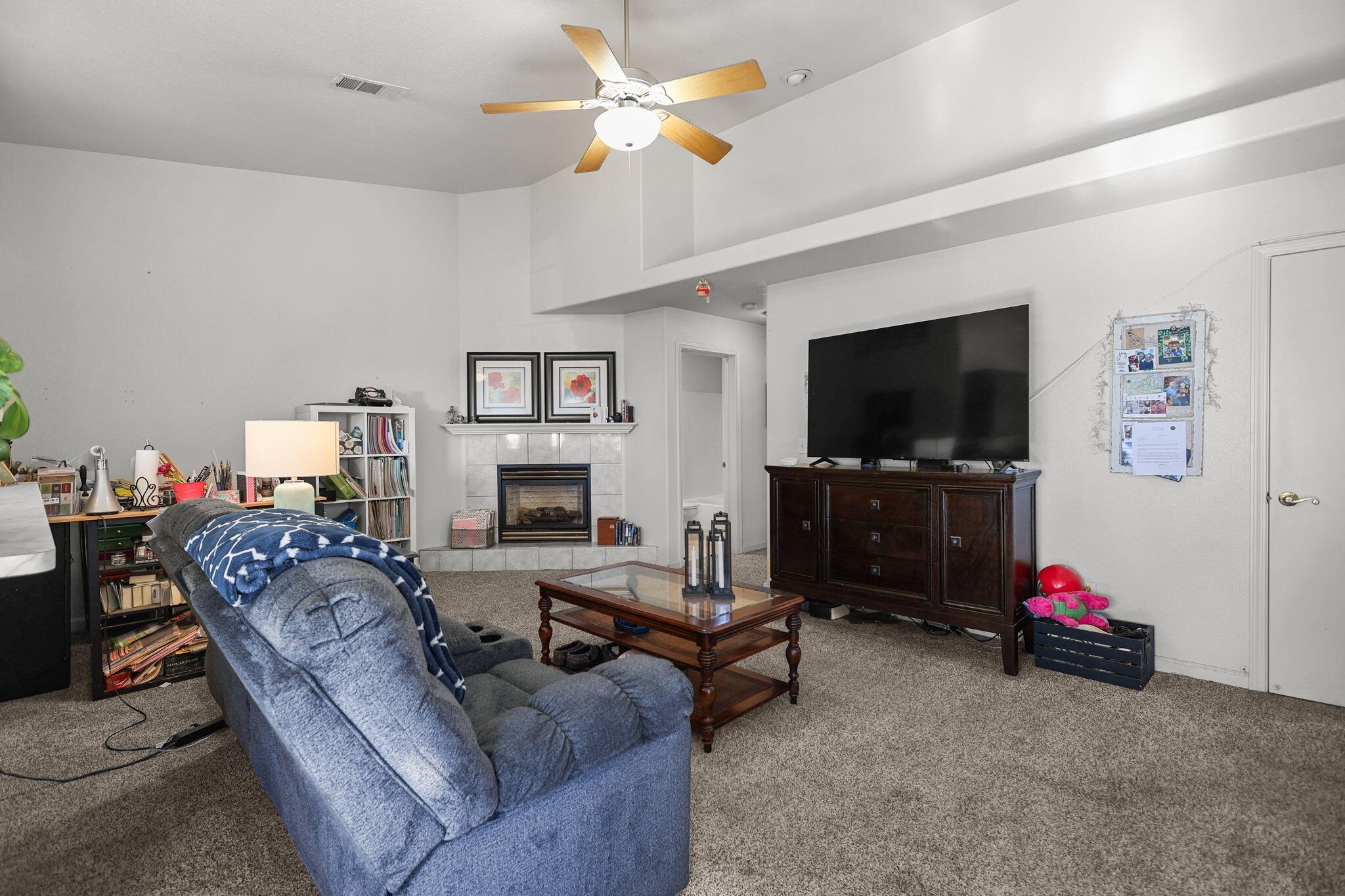 720 Stonebriar Trail Redding, CA 96003 - Photo 6 of 19 a living room with furniture a flat screen tv and a fireplace