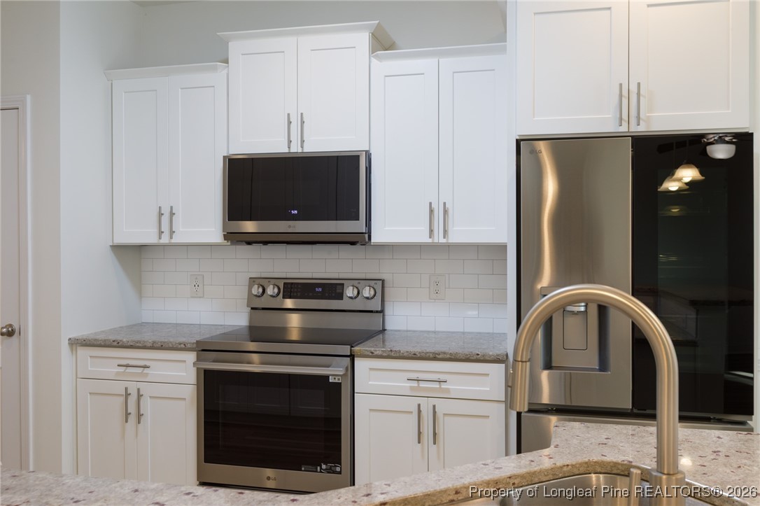600 Burning Tree Road Pinehurst, NC 28374 - Photo 12 of 31 a kitchen with stainless steel appliances granite countertop a stove microwave and refrigerator