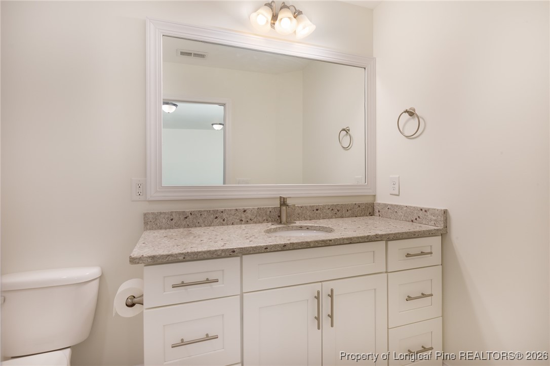 600 Burning Tree Road Pinehurst, NC 28374 - Photo 26 of 32 a bathroom with a granite countertop sink and a mirror