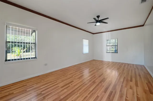 a view of a room with wooden floor and a window