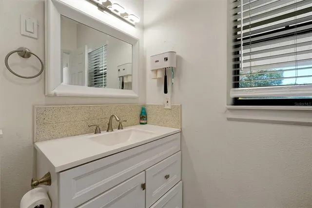 a bathroom with a granite countertop sink and a mirror