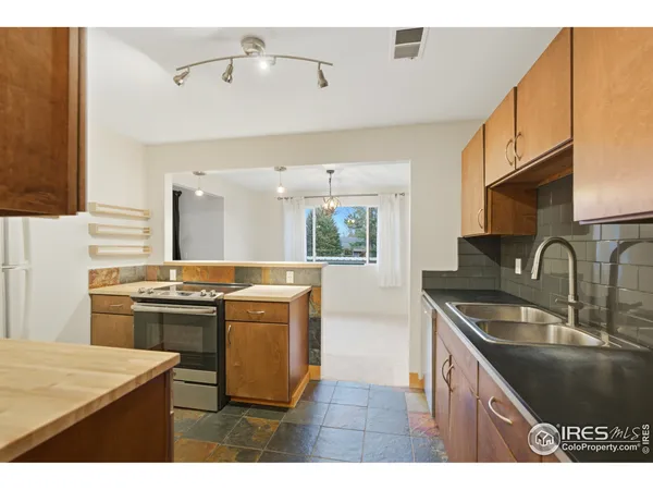 a kitchen with kitchen island a sink stove top oven and cabinets
