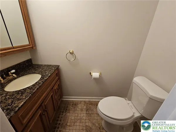 a bathroom with a granite countertop toilet sink and mirror