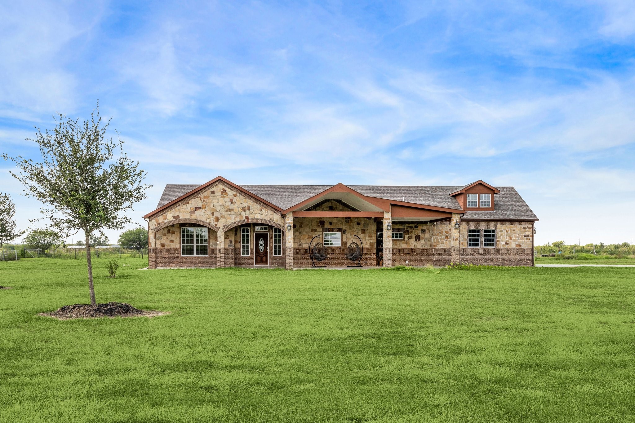 a view of a house with a big yard and large trees