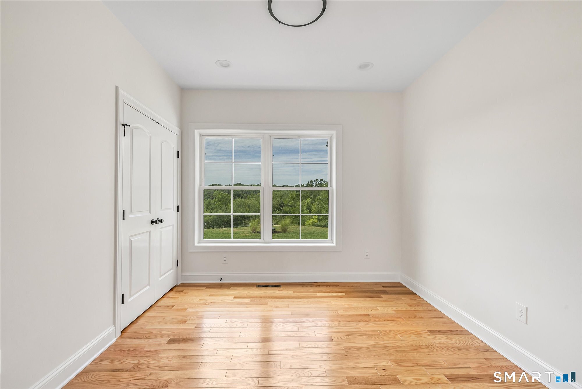 20 Hunting Ridge Road Middlebury, CT 06762 - Photo 19 of 29 a view of an empty room with wooden floor and windows