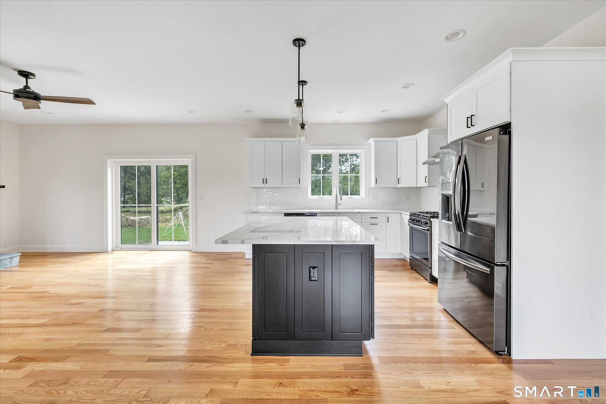 20 Hunting Ridge Road Middlebury, CT 06762 - Photo 8 of 29 a kitchen with stainless steel appliances granite countertop a refrigerator a sink dishwasher a stove and a dining table with wooden floor