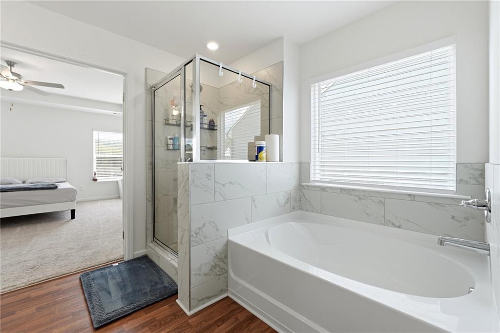 760 Oakmont Trace Canton, GA 30114 - Photo 14 of 25 a bathroom with a tub a window and a glass door shower