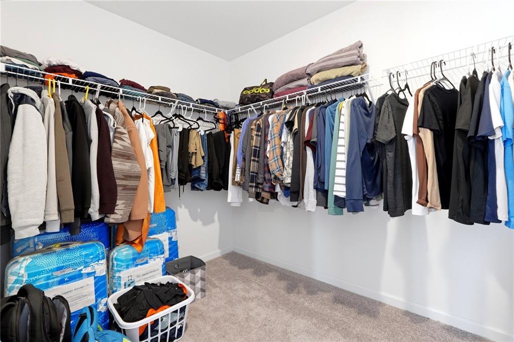 760 Oakmont Trace Canton, GA 30114 - Photo 15 of 25 a view of walk in closet with clothes and shoes