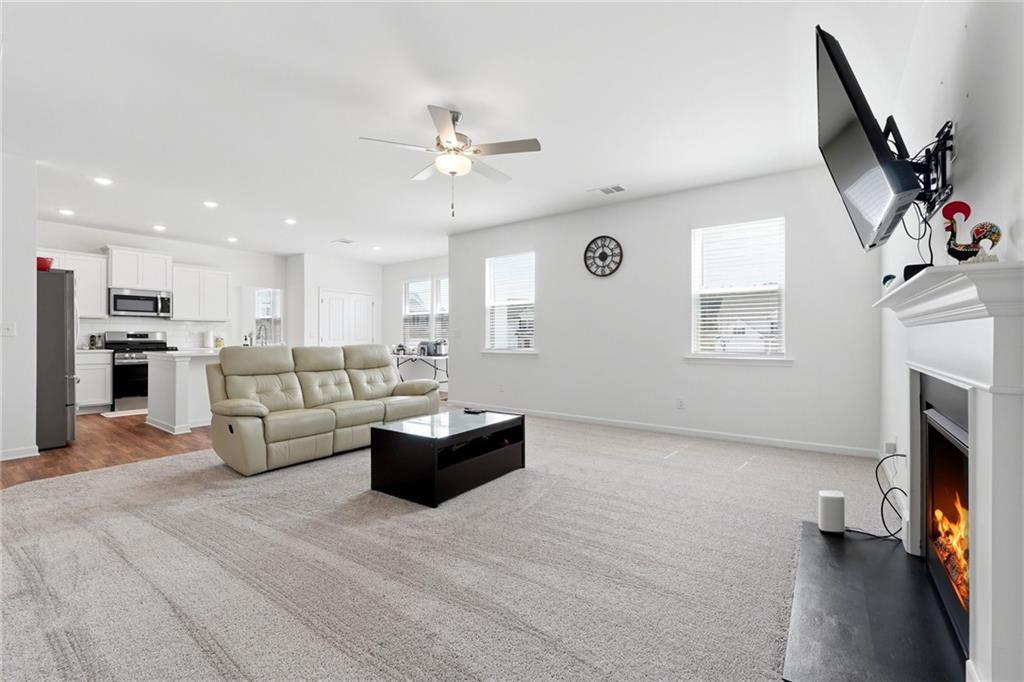 760 Oakmont Trace Canton, GA 30114 - Photo 6 of 25 a living room with furniture a fireplace and a flat screen tv