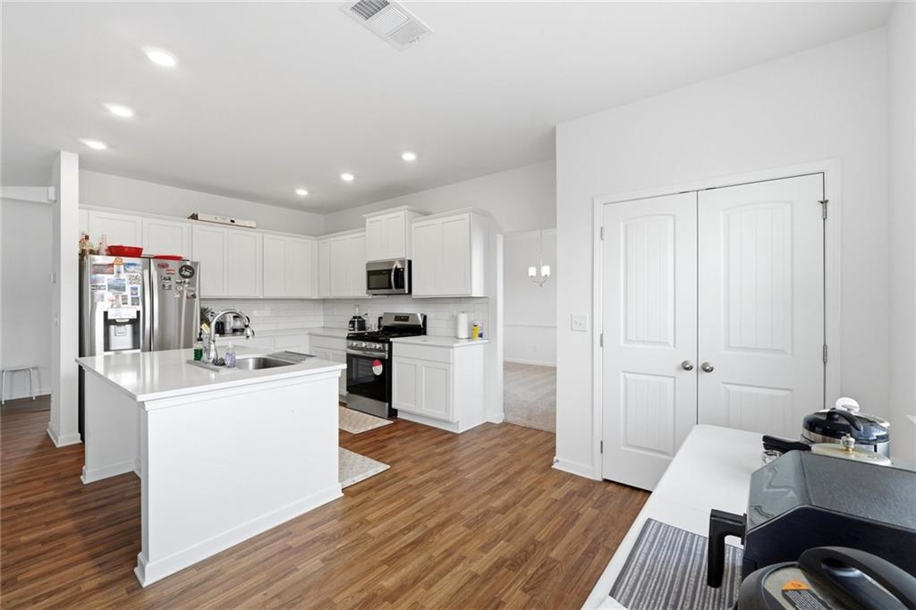 760 Oakmont Trace Canton, GA 30114 - Photo 8 of 25 a kitchen with white cabinets and stainless steel appliances
