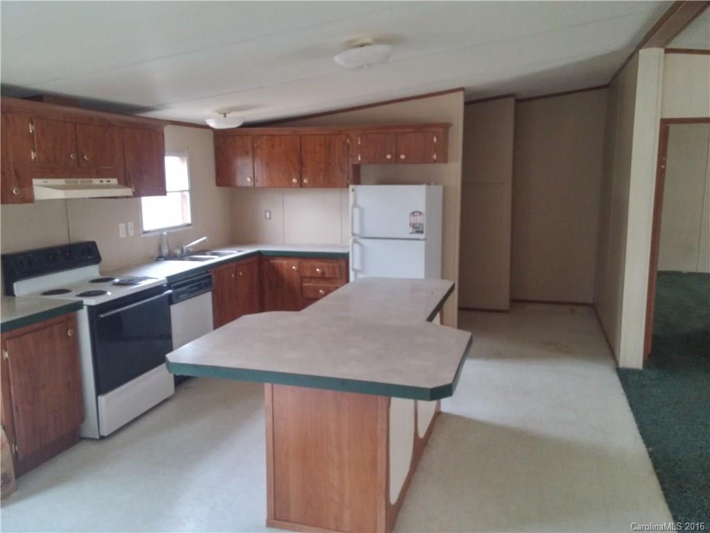 1818 State Rd S-28-55 Lugoff, SC 29078 - Photo 5 of 12 a kitchen with kitchen island cabinets and refrigerator
