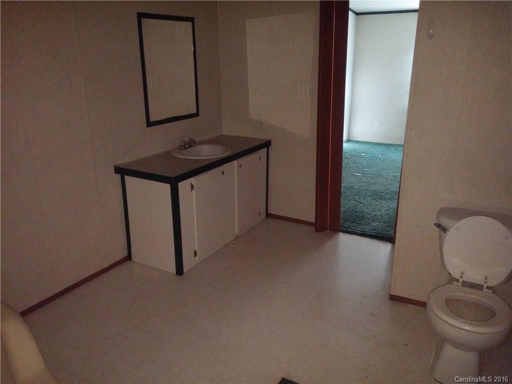 1818 State Rd S-28-55 Lugoff, SC 29078 - Photo 9 of 12 a bathroom with a toilet a sink and mirror