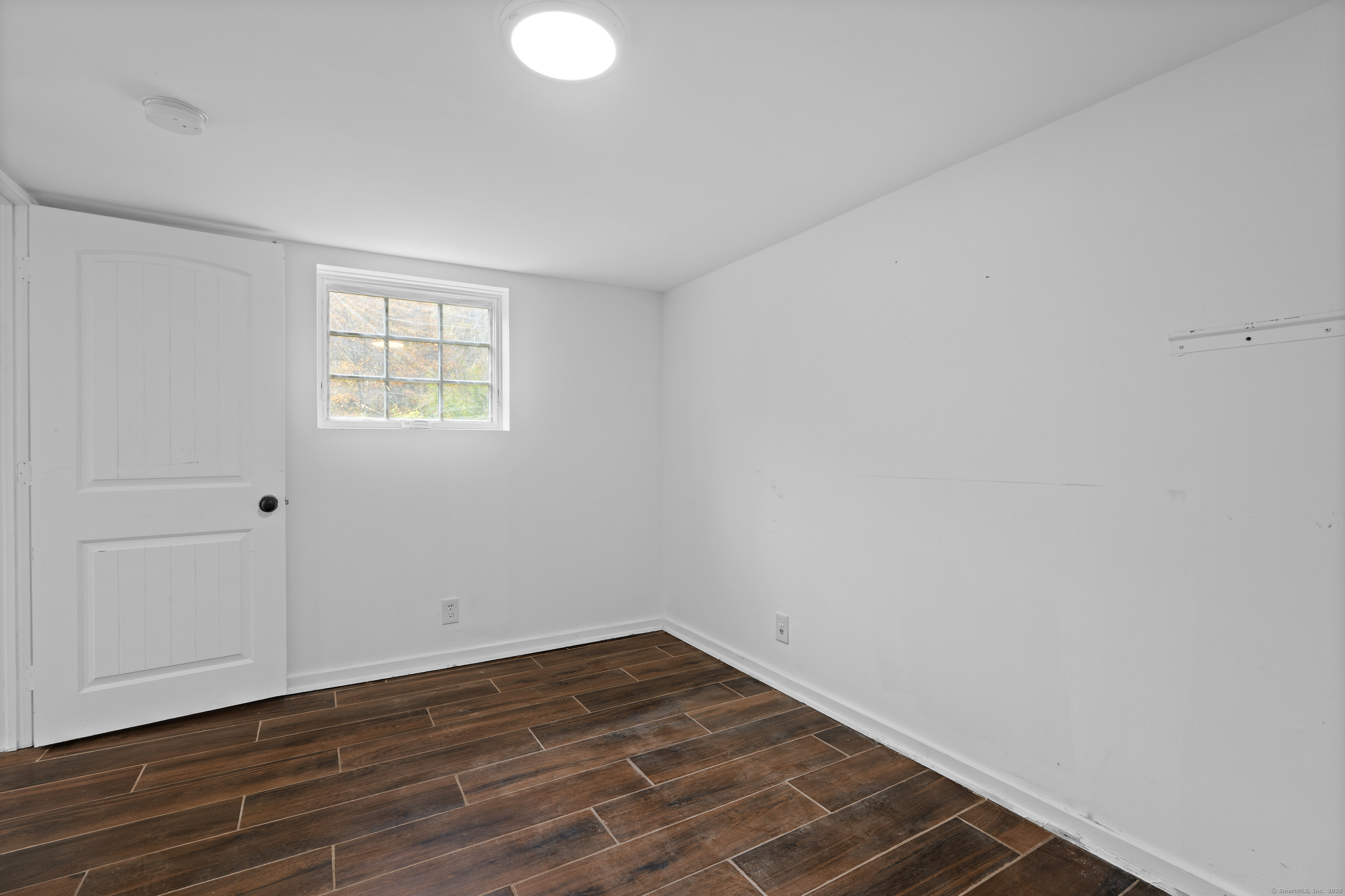 612 Kent Road New Milford, CT 06755 - Photo 31 of 35 a view of an empty room with wooden floor and a window