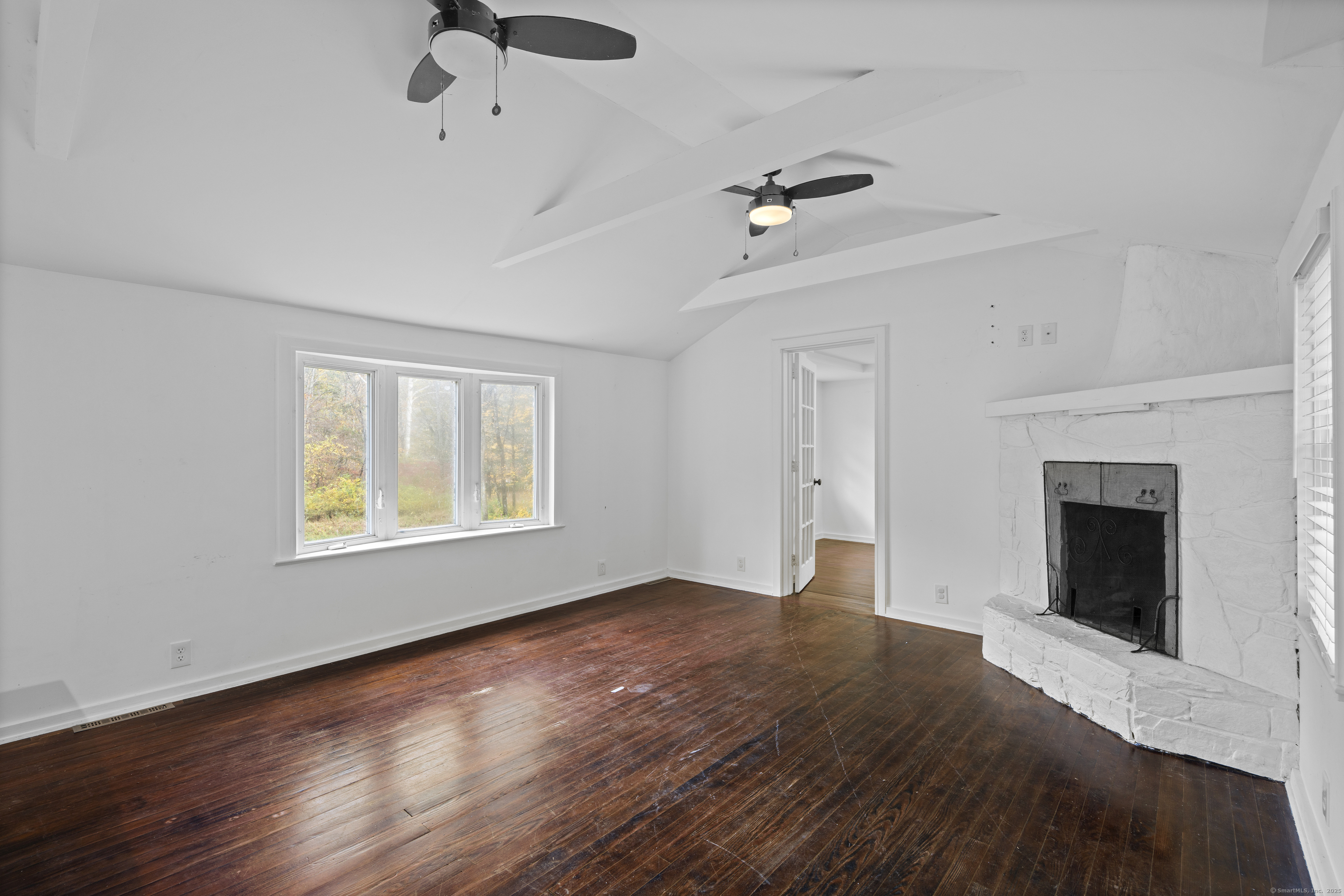 612 Kent Road New Milford, CT 06755 - Photo 8 of 35 a view of an empty room with a fireplace and a window